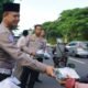 Kasubdit Gakkum Ditlantas Polda Jatim, AKBP Septa Firmansyah saat membagikan takjil gratis nasi kotak kepada pengendara. [3detik.com]