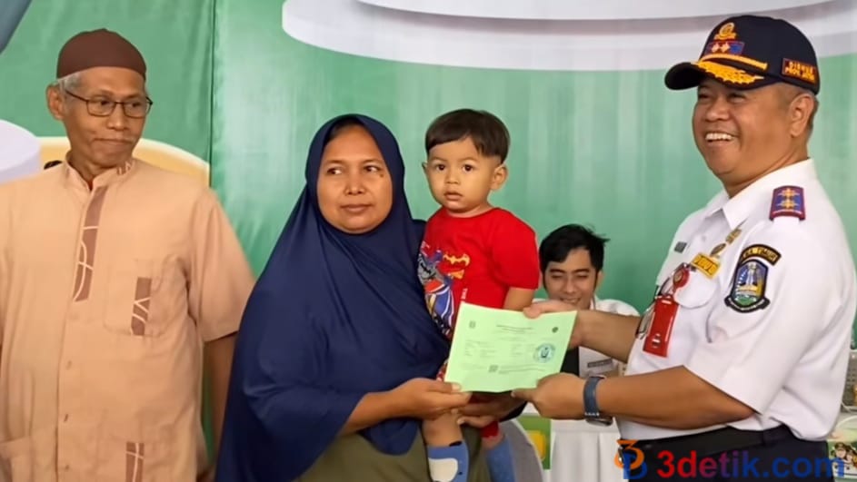 simbolis penyerahan: Kadishub Provinsi Jawa Timur, Nyono saat menyerahkan tiket mudik gratis kepada salah satu peserta mudik. [3detik.com]