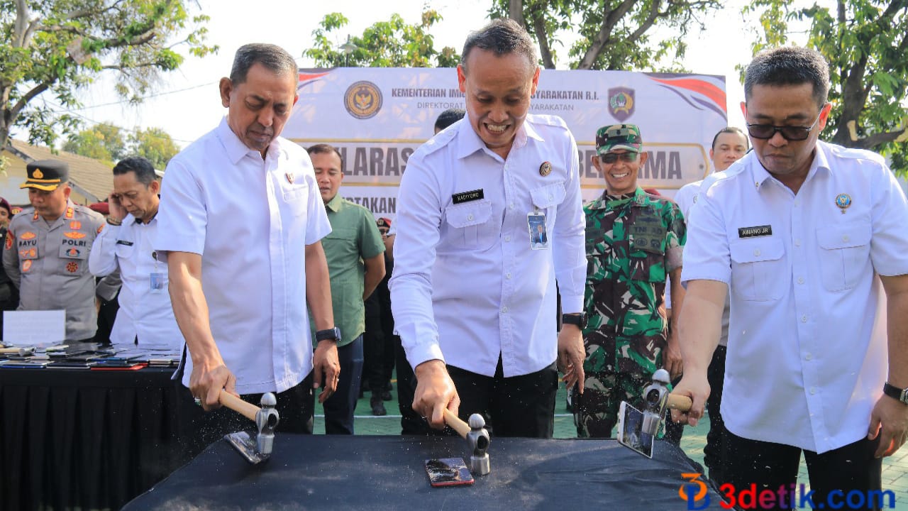 Kakanwil Ditjen PAS Jatim, Kadiyono (tengah) saat memusnahkan handphone. [3detik.com]